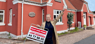Helle K. Ringgaard, Ejendomsmægler, MDE i Ejendomsmæglerfirmaet John Frandsen Bjerringbro og Kjellerup med solgt skilt foran bolig.